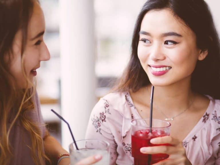 Two women enjoying glasses of Finlays iced tea with straws